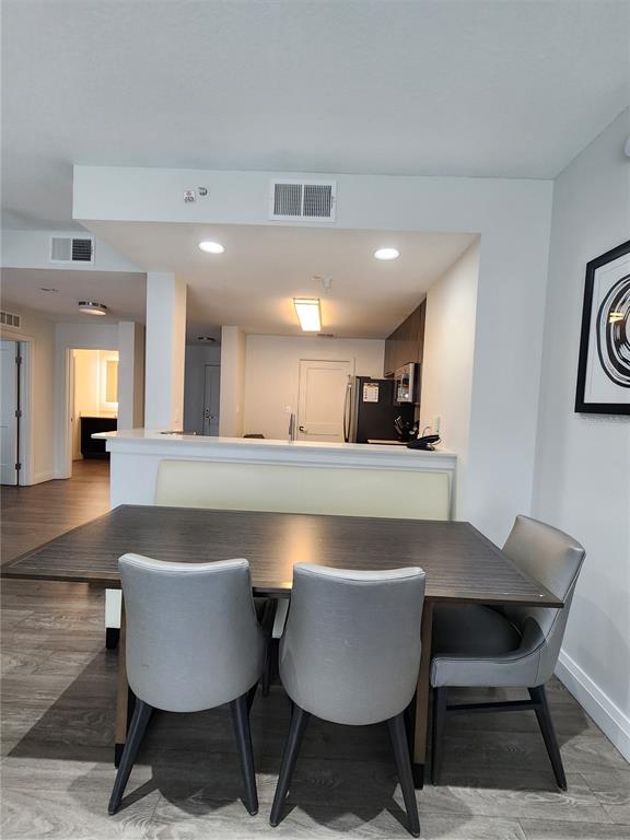 A dining area with a table and chairs sits in front of a kitchen island — 14501 GROVE RESORT AVENUE UNIT 3737, WINTER GARDEN, FL