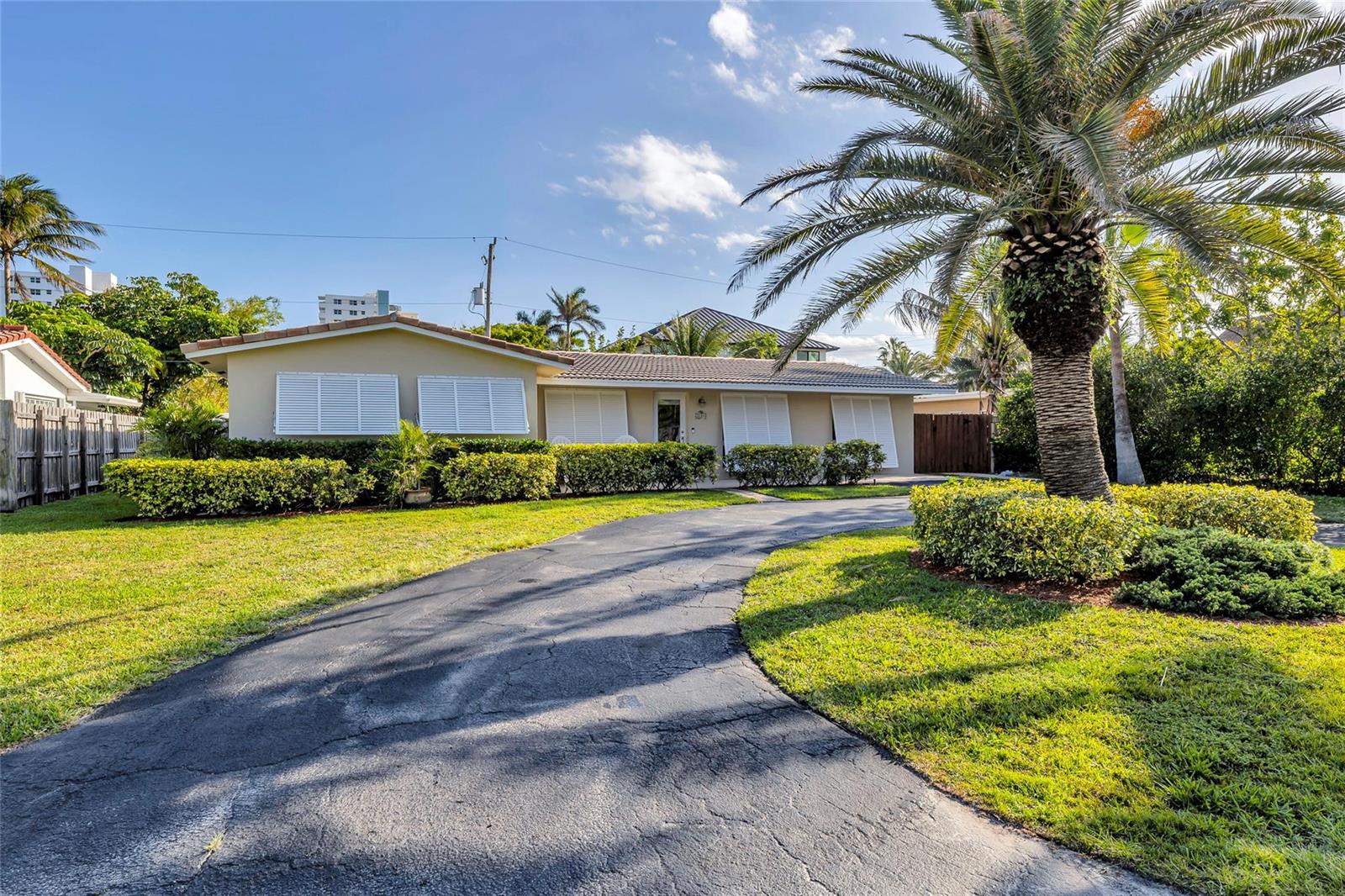 A single-story house with a curved driveway, palm tree, and white shutters on the windows — 3404 Barton Road, Pompano Beach FL 33062, POMPANO BEACH, FL