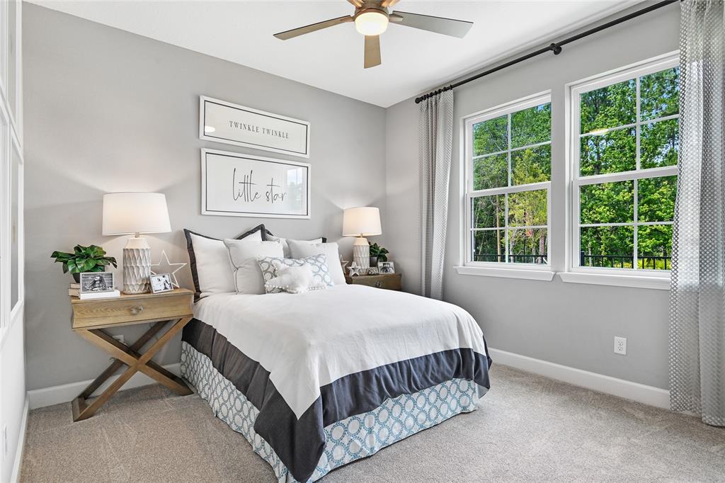 A bedroom features a bed with a patterned skirt, two nightstands, and two windows — 49 PONCE PRESERVE DRIVE, PALM COAST, FL