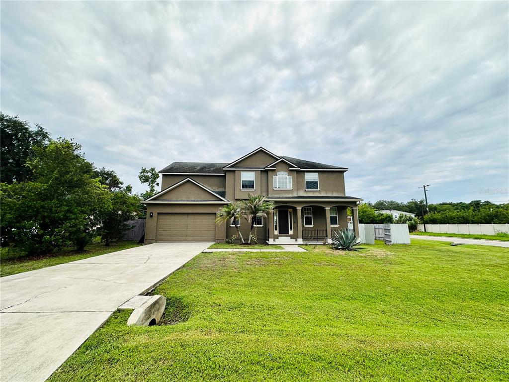 A two-story house with a brown stucco exterior, a two-car garage, and a large lawn — 438 PALM DRIVE, SANFORD, FL