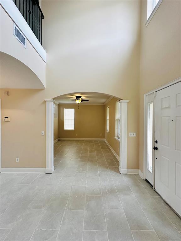 An entryway with tile flooring leads through an arched opening into a dining room — 438 PALM DRIVE, SANFORD, FL