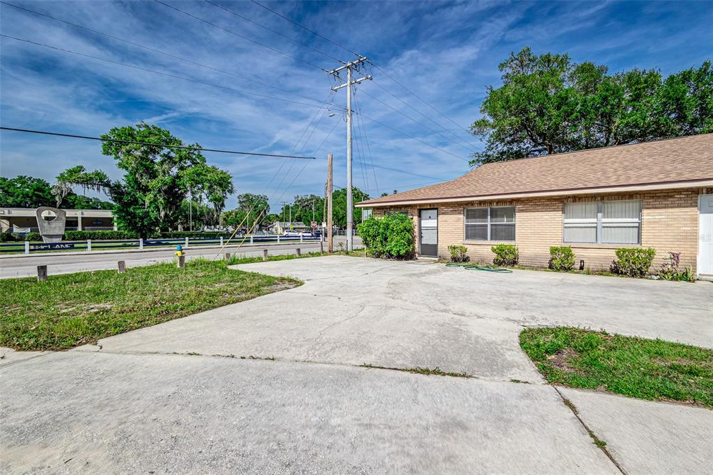 A single-story brick building with a concrete parking area and a utility pole outside — 401 BIG CEDAR WAY UNIT A, BRANDON, FL