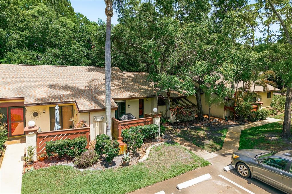An exterior view of a single-story residential building with a brown roof and patio — 4041 ARROWWOOD COURT UNIT 4041, PALM HARBOR, FL