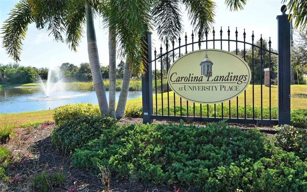 A sign for Carolina Landings at University Place stands before a pond with a fountain — 7658 PLANTATION CIRCLE, BRADENTON, FL