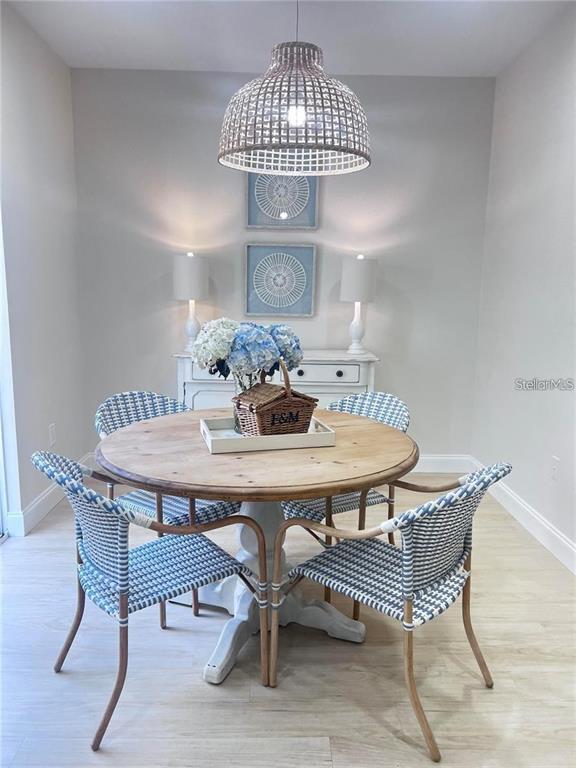 A dining room features a round wooden table, four woven chairs, and a pendant light — 7658 PLANTATION CIRCLE, BRADENTON, FL