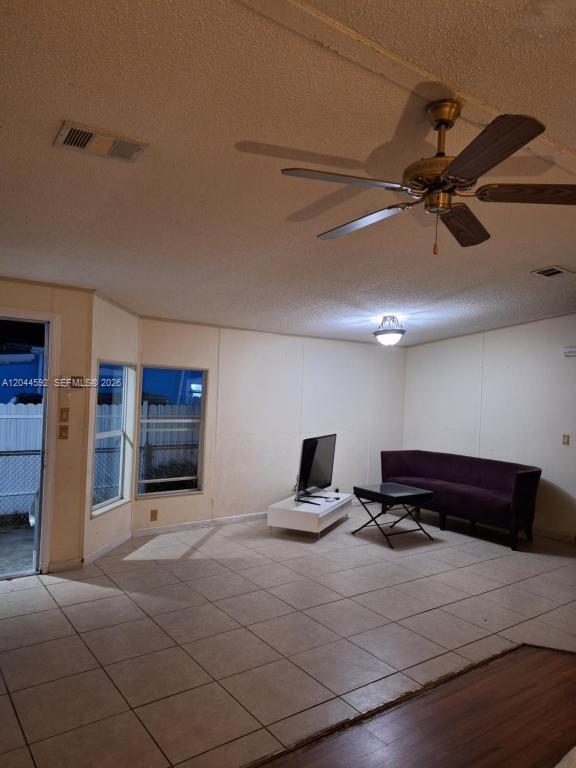 A living room features tile flooring, a ceiling fan, a television, and a purple sofa — 1233 SW 130 Ave # 1233, Miami FL 33184, MIAMI, FL