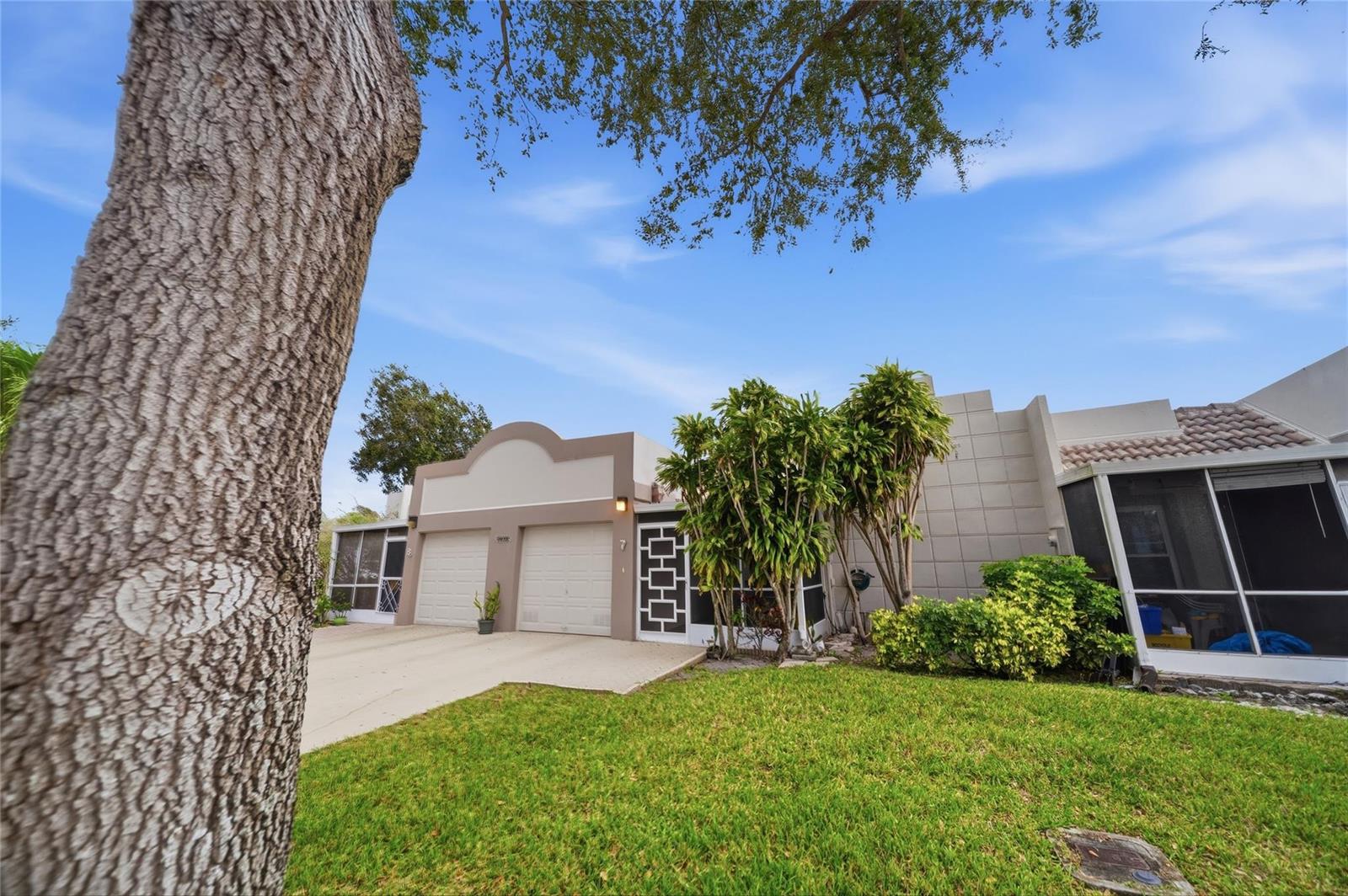 A single-story house with a two-car garage, a screened-in porch, and a large tree — 18730 Stewart Circle # 7, Boca Raton FL 33496, BOCA RATON, FL