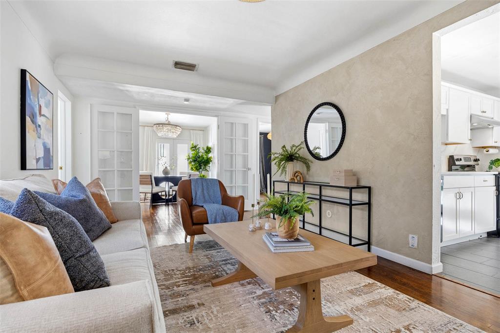 A living room features a beige sofa, leather armchair, wooden coffee table, and textured wall — 5931 MANGROVE STREET N, ST PETERSBURG, FL