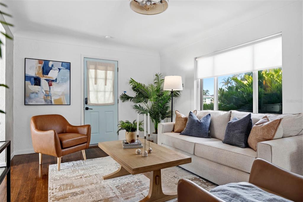 A living room features a light-colored sofa, two leather armchairs, a wooden coffee table, and a plant — 5931 MANGROVE STREET N, ST PETERSBURG, FL