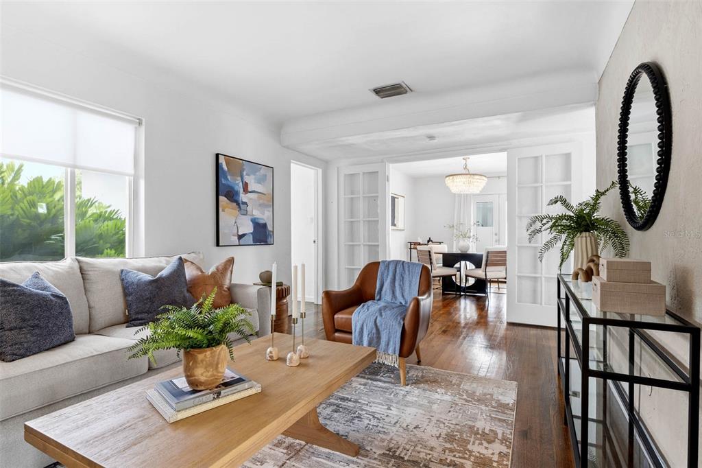 A living room features a gray sofa, a wood coffee table, and a leather armchair — 5931 MANGROVE STREET N, ST PETERSBURG, FL