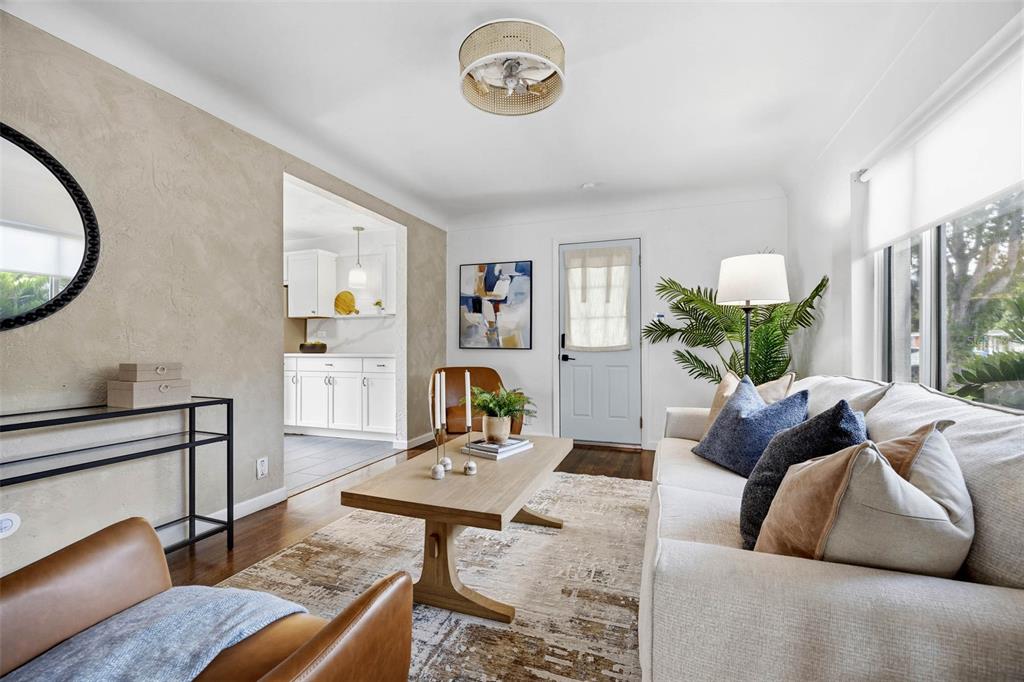 A living room features a beige sofa, leather armchairs, a wooden coffee table, and textured walls — 5931 MANGROVE STREET N, ST PETERSBURG, FL