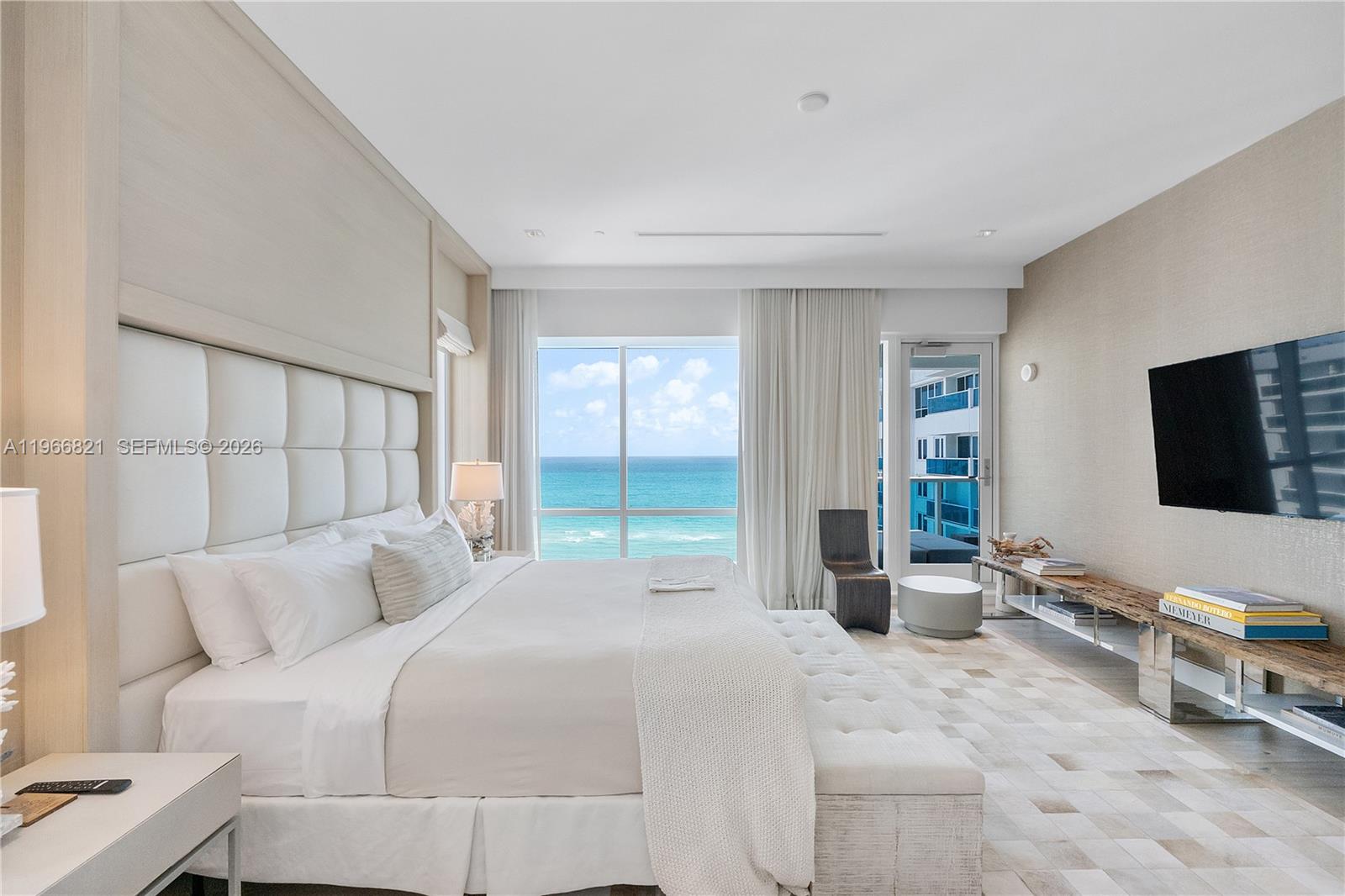 A modern bedroom features a king bed, ocean views, and a wall-mounted television — 102 24th St # 1612, Miami Beach FL 33139, MIAMI BEACH, FL