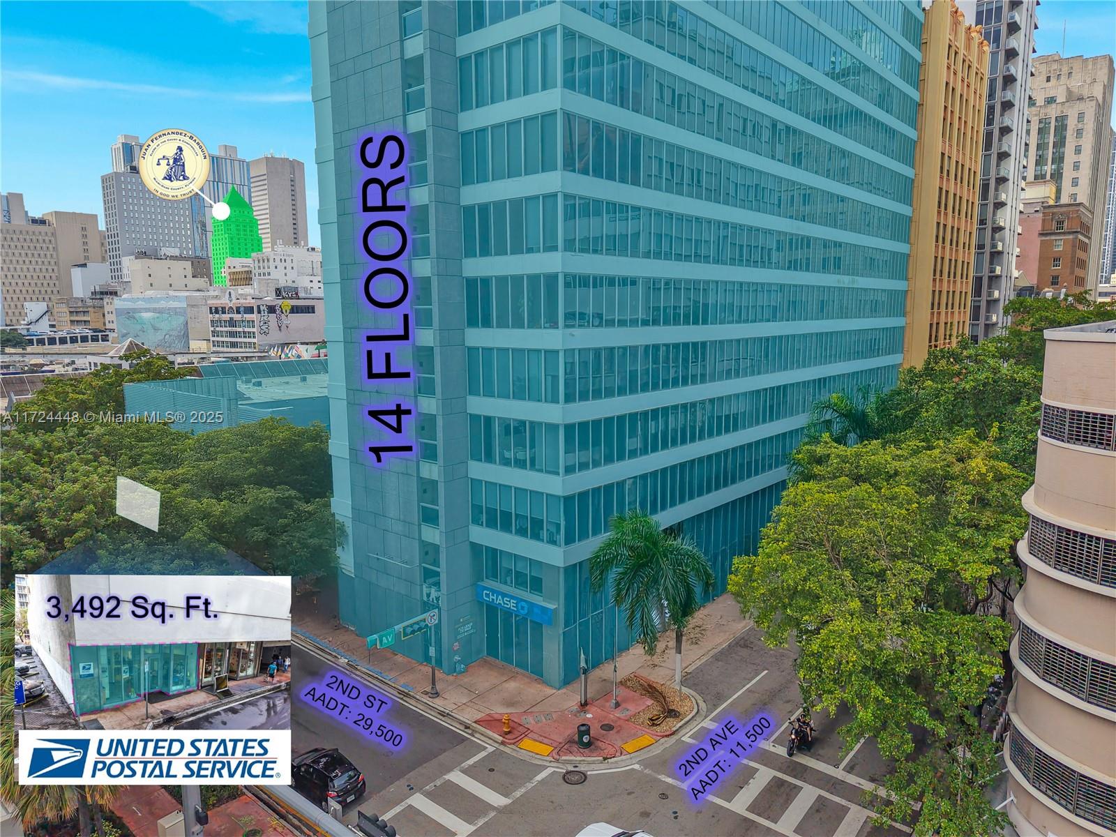 An aerial view shows a glass-facade office building at a street corner in a city — 150 SE 2nd Ave # 103, Miami FL 33131, MIAMI, FL