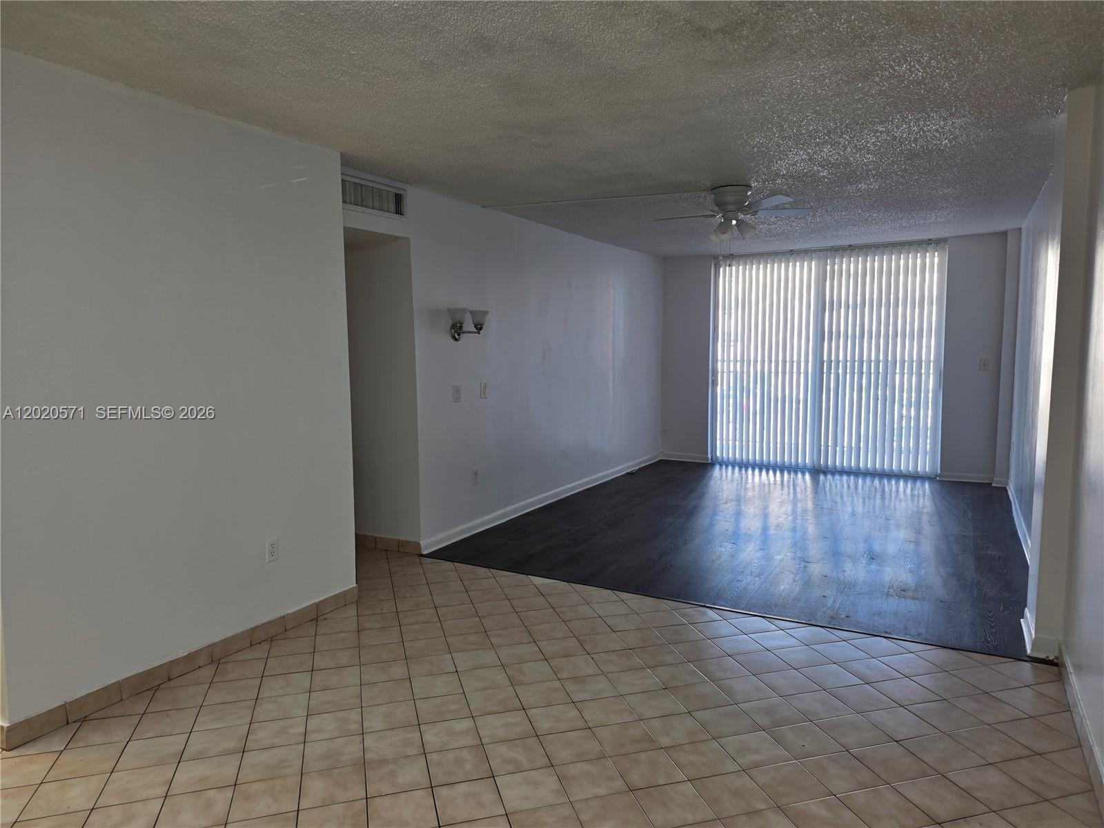 An interior view shows a living area with dark wood flooring and tiled flooring — 14150 SW 84th St # I, Miami FL 33183, MIAMI, FL