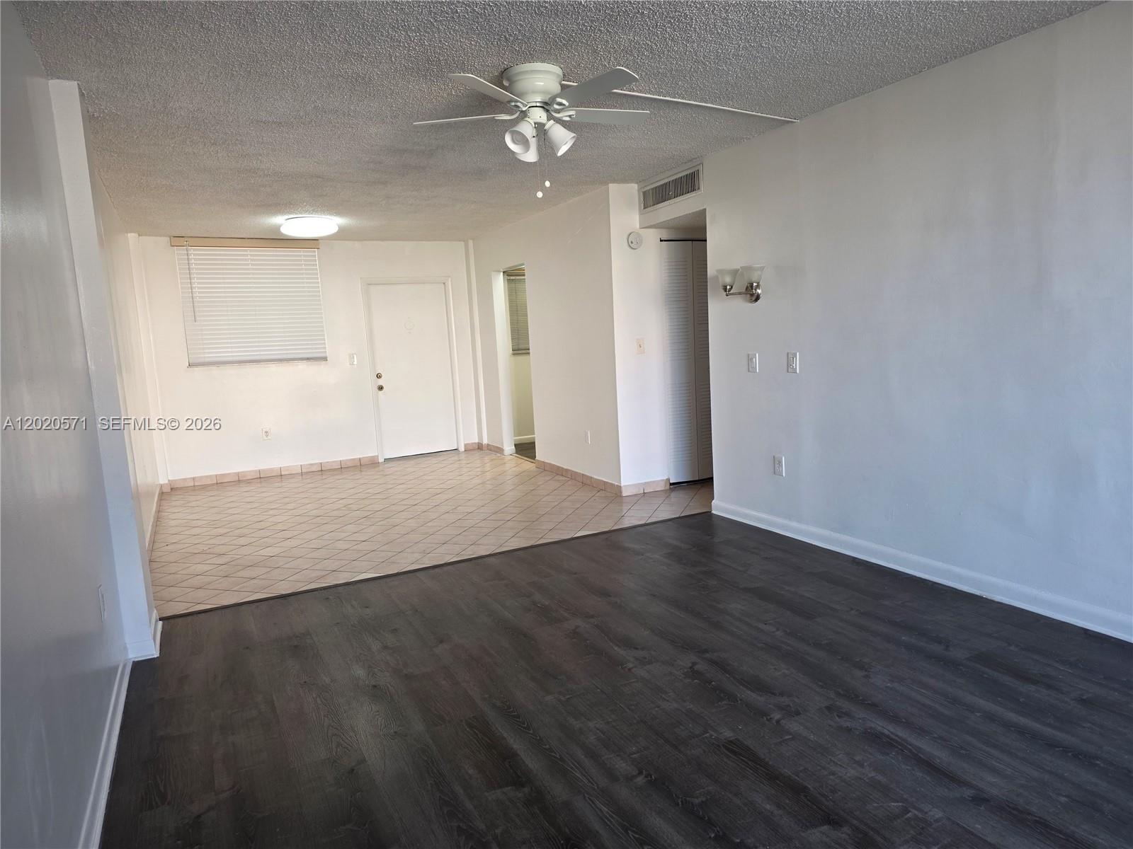 An interior view shows a living area with dark wood flooring and a tiled entryway — 14150 SW 84th St # I, Miami FL 33183, MIAMI, FL