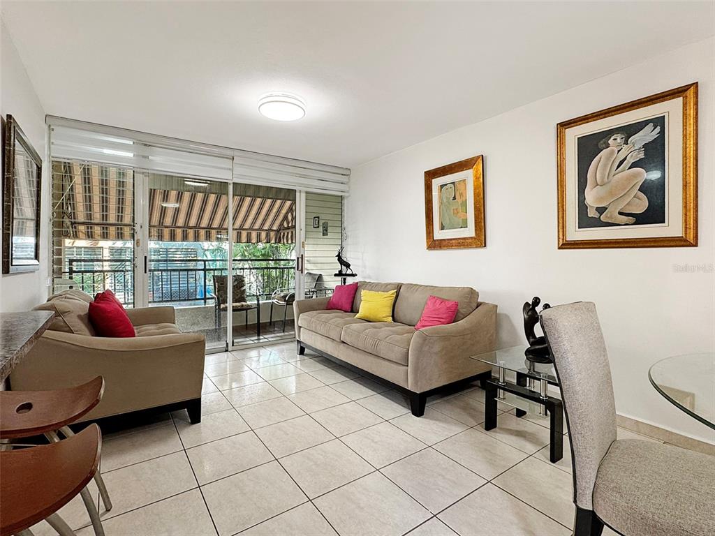 A living room features a beige sofa, a loveseat, tiled floors, and a sliding glass door — Cond Valles de Torrimar BLVD. PEDRO FULLANA VIRELLA UNIT D-212, GUAYNABO, PR