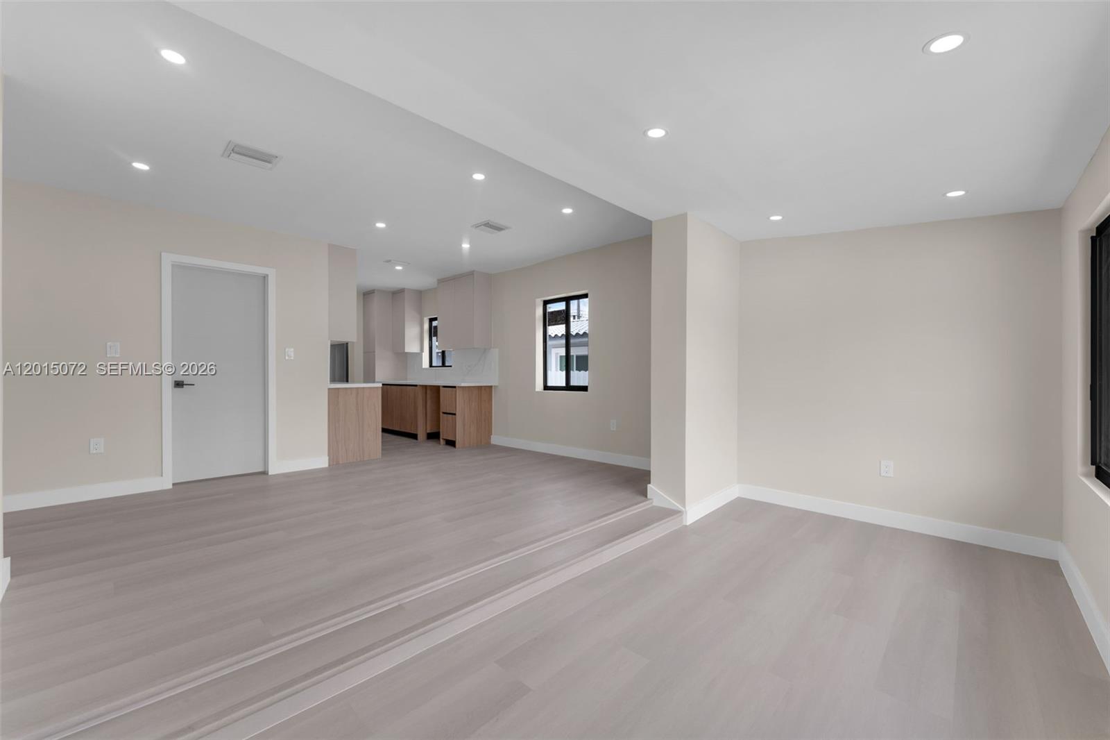 An open-concept living area features light wood-look flooring, a sunken floor level, and a kitchen — 3250 SW 68th Ave, Miami FL 33155, MIAMI, FL