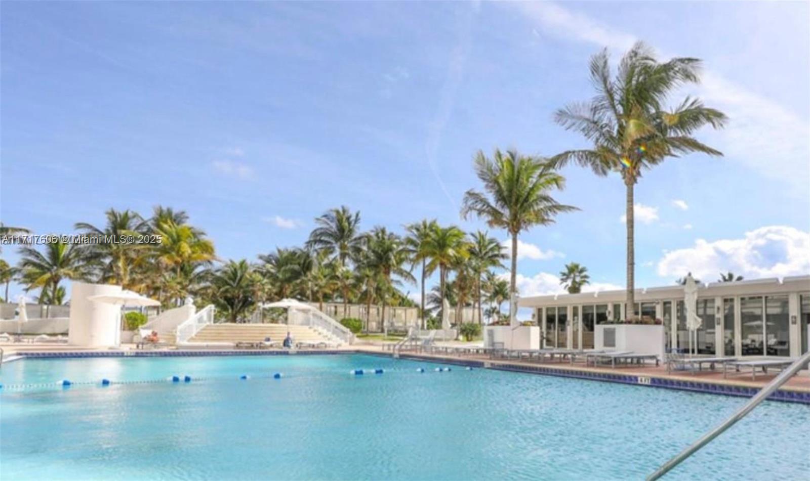 A swimming pool is surrounded by palm trees and a modern building with glass doors — 10275 Collins Ave # 331, Bal Harbour FL 33154, BAL HARBOUR, FL