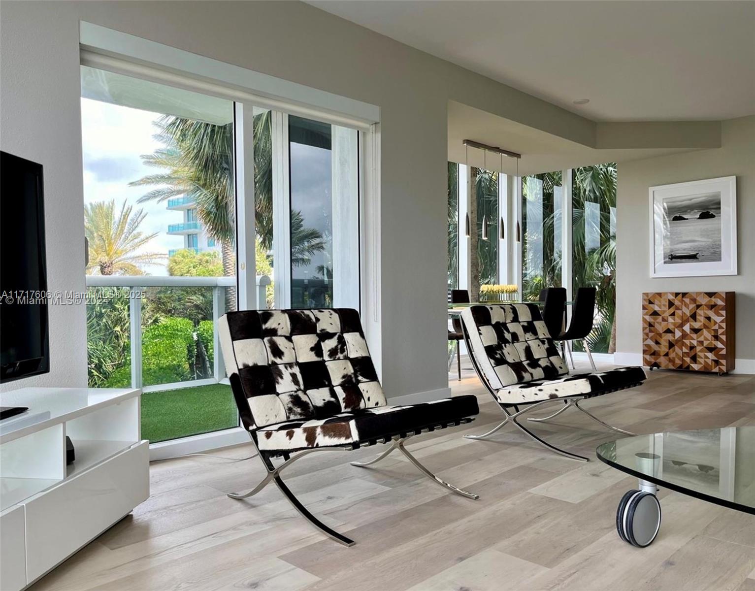 A living room features two cowhide Barcelona chairs, light wood flooring, and floor-to-ceiling windows — 10275 Collins Ave # 331, Bal Harbour FL 33154, BAL HARBOUR, FL