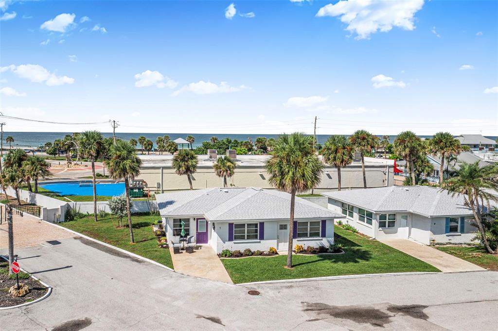 An aerial view shows two white single-story houses with palm trees and a nearby ocean — 1 PEARL STREET UNIT 1, ENGLEWOOD, FL