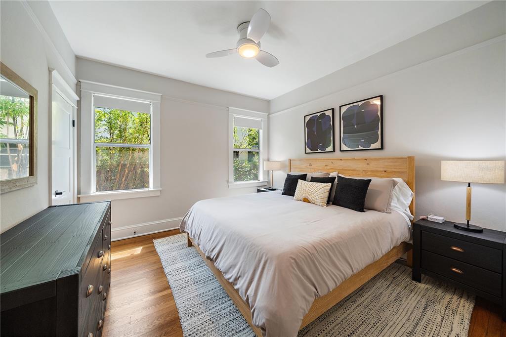 A bedroom features a wooden bed frame, two windows, a ceiling fan, and dark furniture — 320 OHIO PLACE, SARASOTA, FL