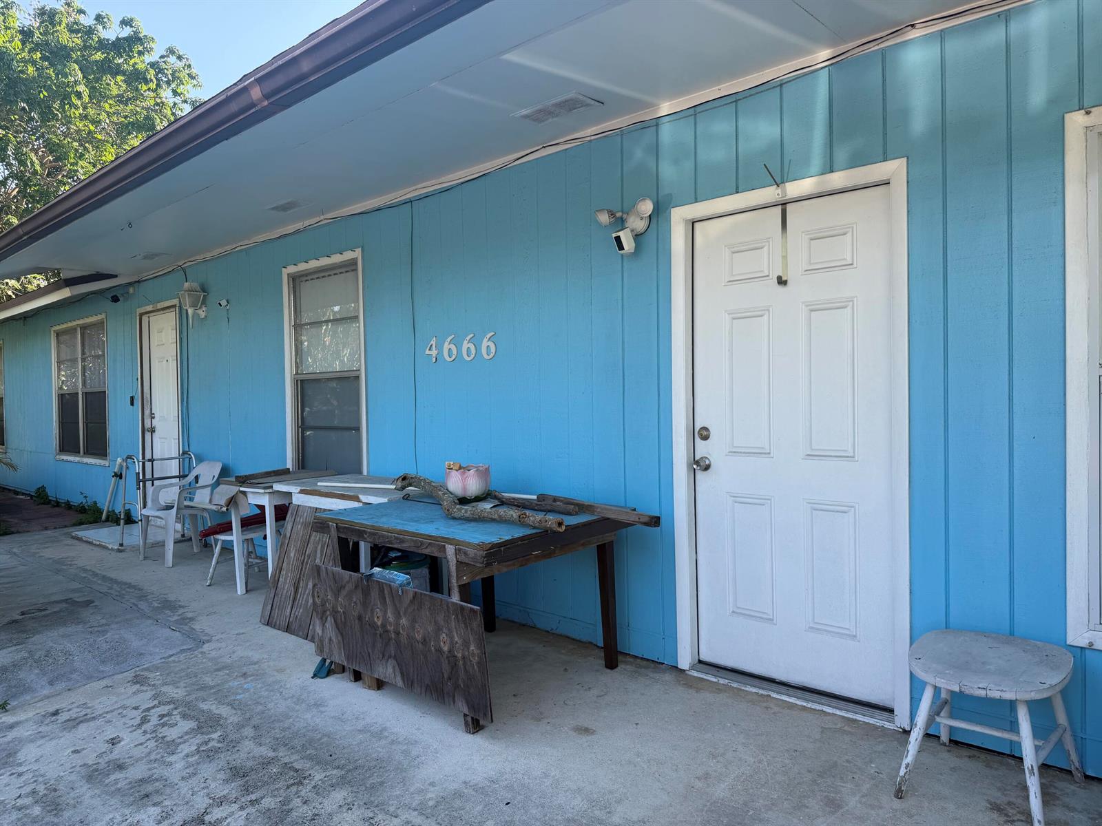 The exterior of a blue building features a white door, a window, and a table — 4666 E Holt, West Palm Beach FL 33415, WEST PALM BEACH, FL