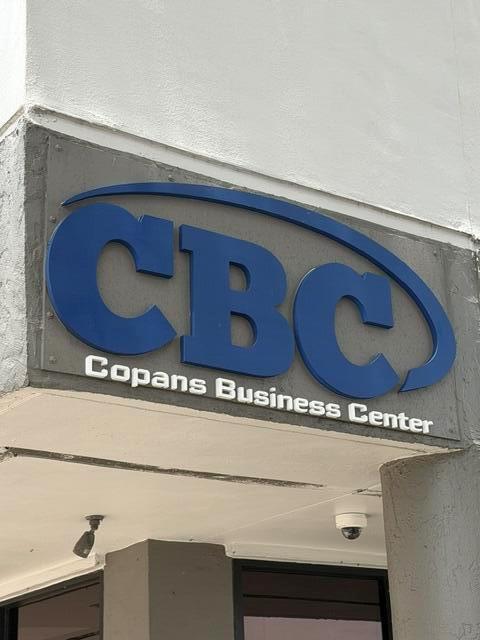 A blue sign reading CBC Copans Business Center is mounted on a gray exterior wall — 2560 N Powerline Road # 201, Pompano Beach FL 33060, POMPANO BEACH, FL