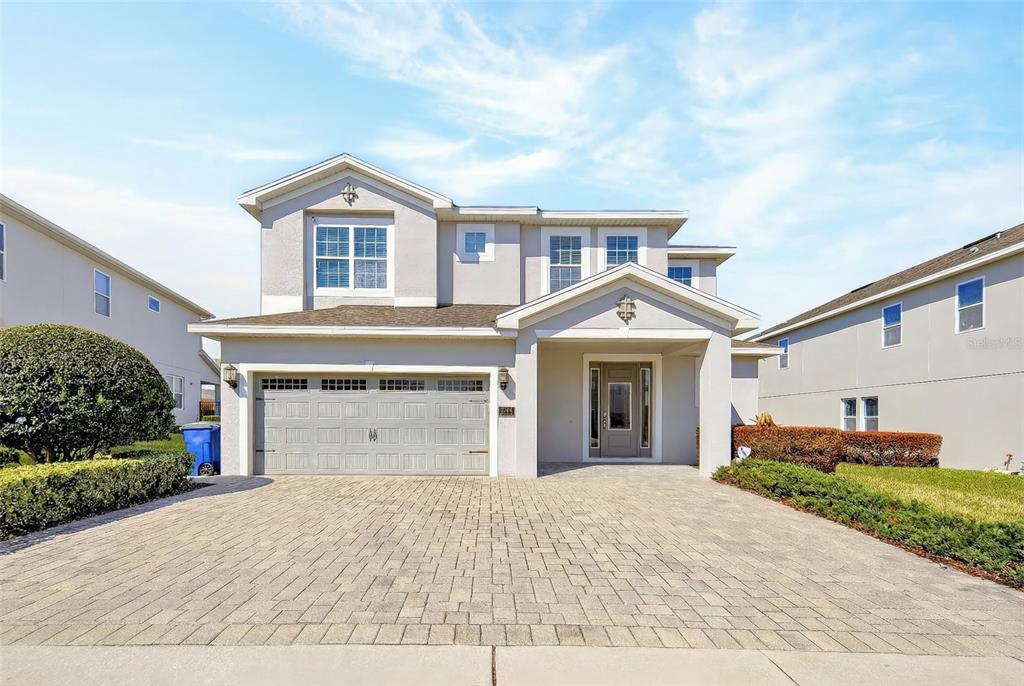 A two-story house with a paved driveway, a two-car garage, and a covered front entrance — 7724 FAIRFAX DRIVE, KISSIMMEE, FL