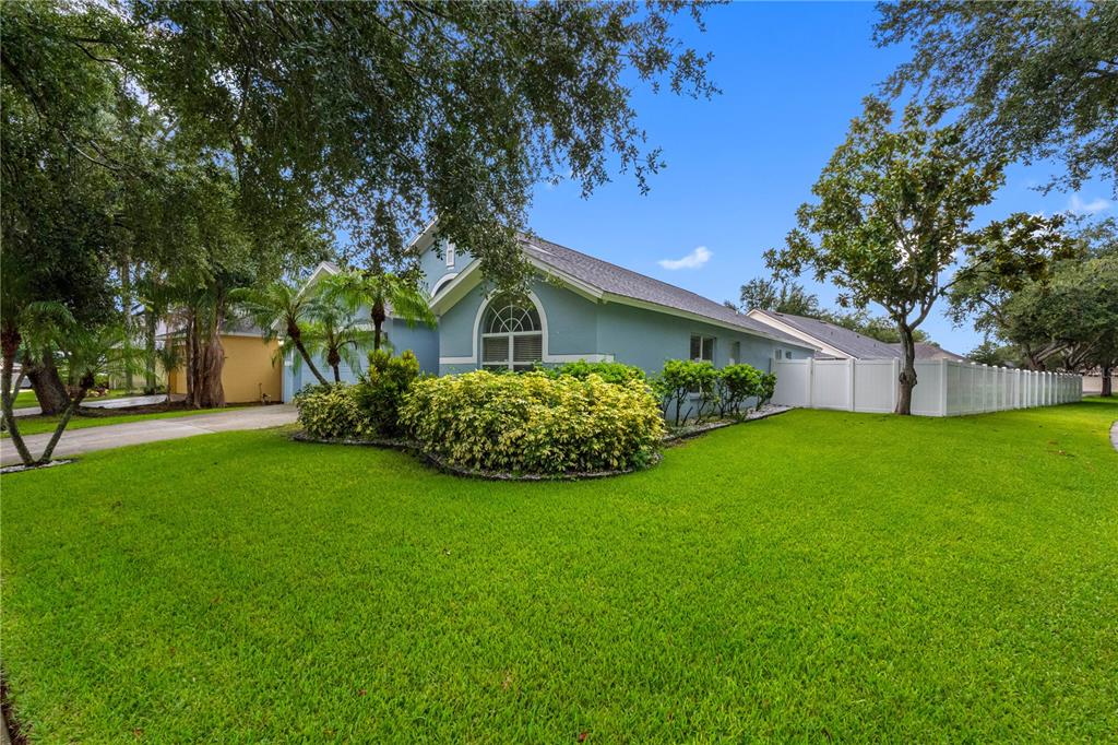 A blue single-story house with a white fence and a large front lawn — 3306 PIN OAK LANE, TAMPA, FL
