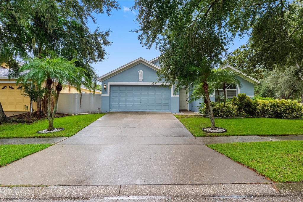 A blue single-story house with a two-car garage and a concrete driveway — 3306 PIN OAK LANE, TAMPA, FL