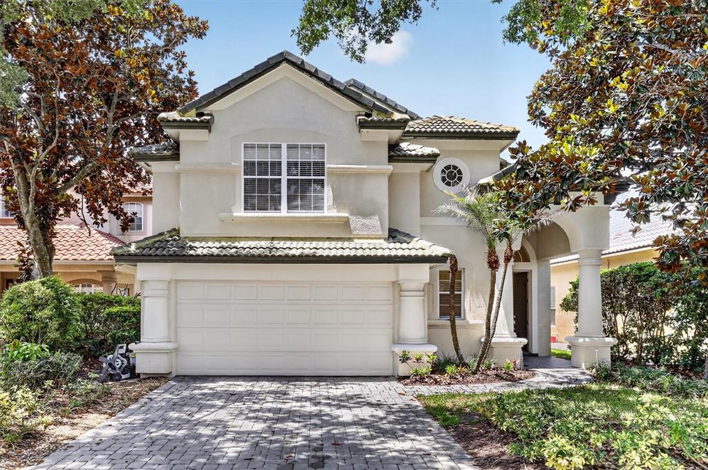 A two-story house with a paved driveway, a single-car garage, and a covered entryway — 8506 SAINT MARINO BOULEVARD, ORLANDO, FL
