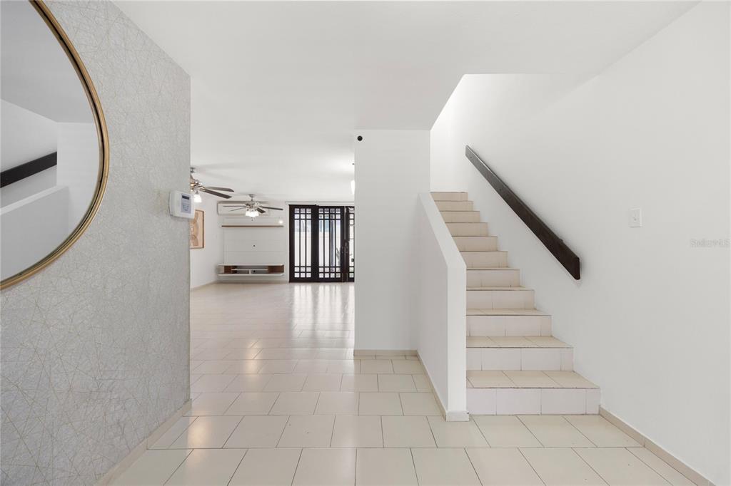 An interior view shows a tiled entryway with a staircase and an open living area — 6 PRADO ALTO, GUAYNABO, PR