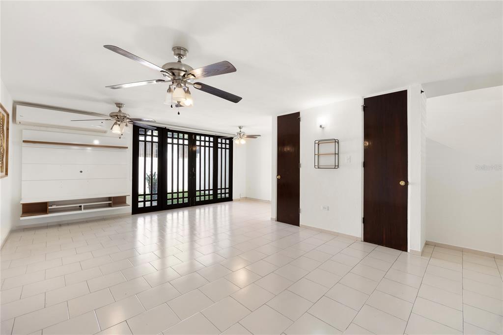 A bright living room features white tile floors, ceiling fans, and dark wood doors — 6 PRADO ALTO, GUAYNABO, PR