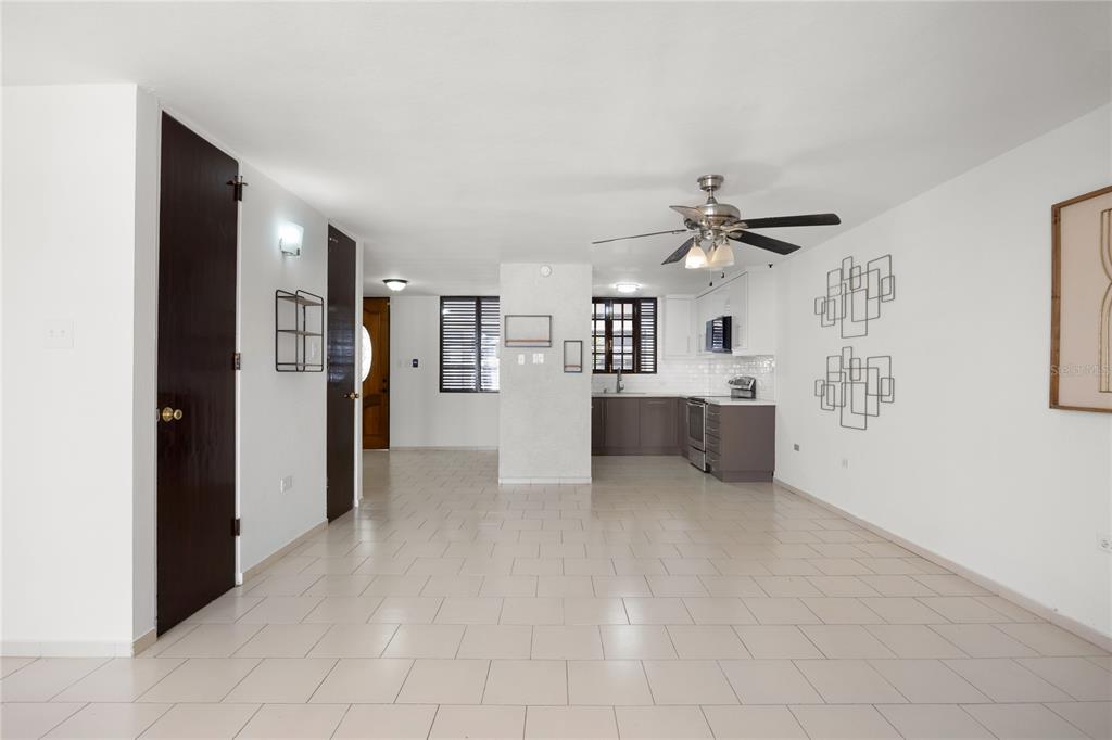 An open-concept living area with light tile flooring, white walls, and a kitchen in back — 6 PRADO ALTO, GUAYNABO, PR
