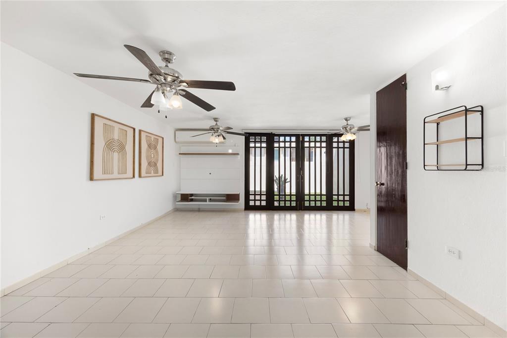 A living room with white tile floors, two ceiling fans, and dark-framed glass doors — 6 PRADO ALTO, GUAYNABO, PR