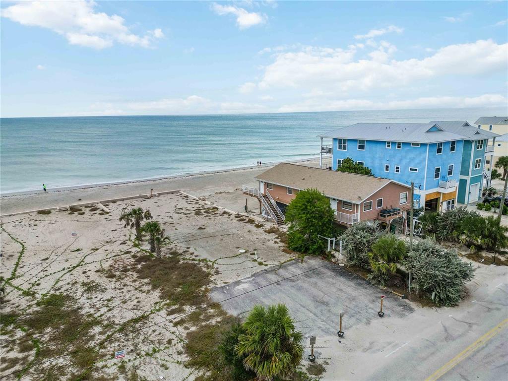 An aerial view shows a sandy beachfront lot next to a house and the ocean — 1120 SHORE VIEW DRIVE UNIT D, ENGLEWOOD, FL