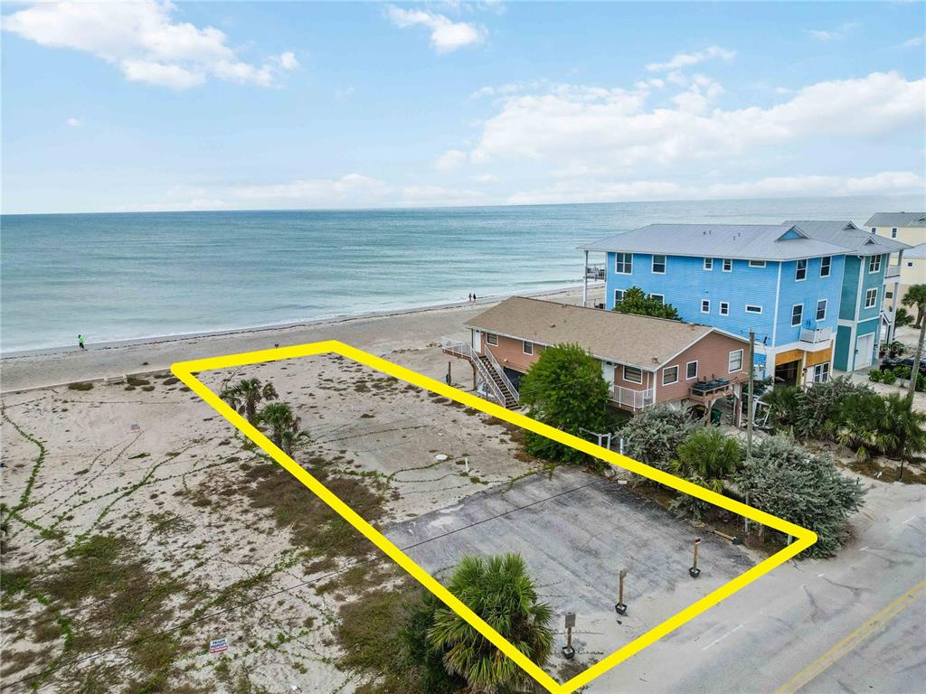 An aerial view shows a vacant, rectangular beachfront lot bordered by a road and sand — 1120 SHORE VIEW DRIVE UNIT D, ENGLEWOOD, FL