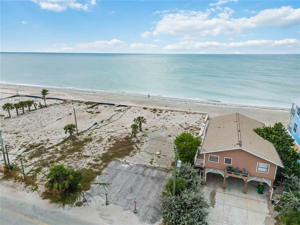 An aerial view shows a beach house next to a vacant lot by the ocean — 1120 SHORE VIEW DRIVE UNIT D, ENGLEWOOD, FL