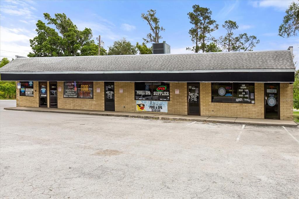 A single-story commercial strip mall building with a brick facade and a parking lot — 5053 SE ABSHIER BLVD BOULEVARD, BELLEVIEW, FL