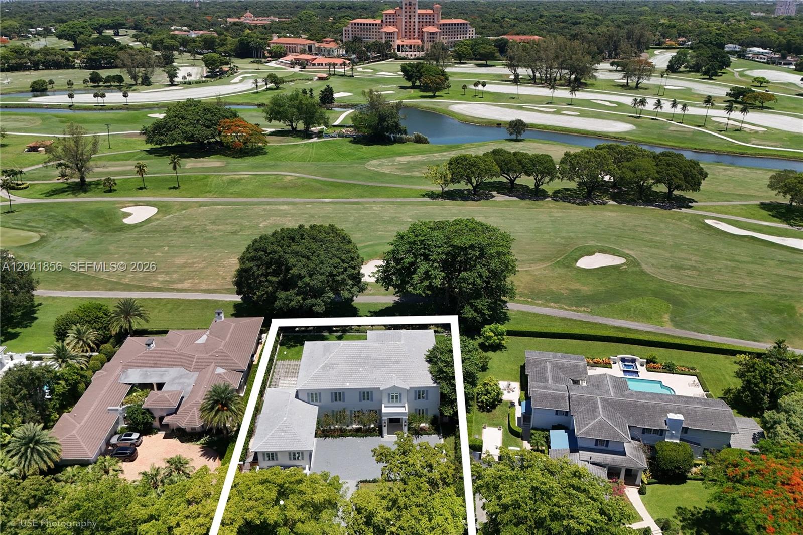An aerial view shows a house with a white outline situated next to a golf course — 1241 Mariola Ct, Coral Gables FL 33134, CORAL GABLES, FL
