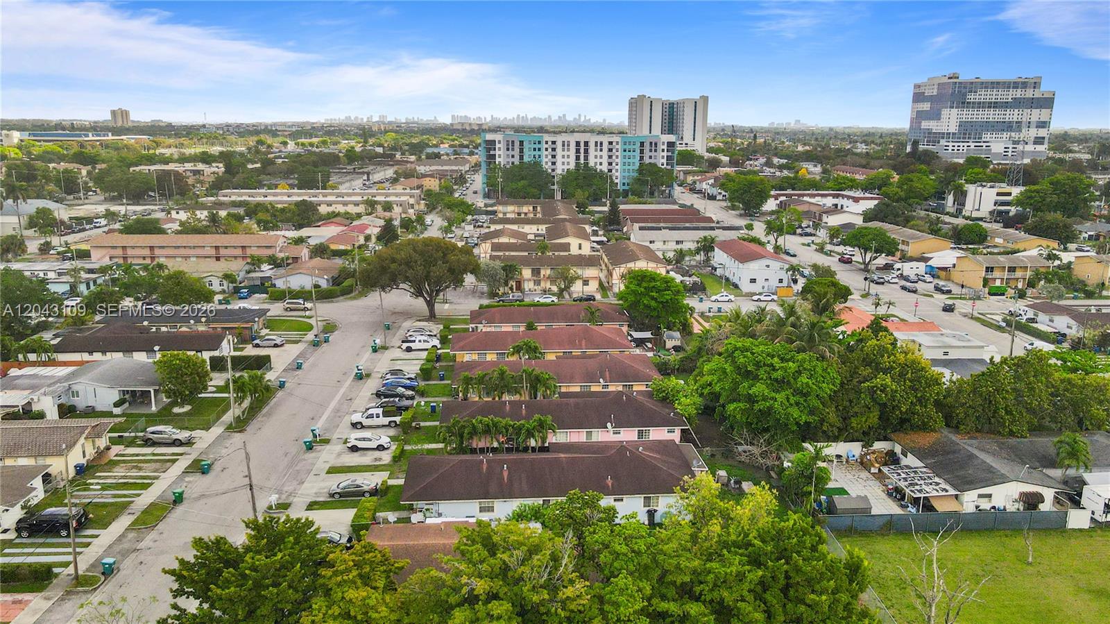 An aerial view shows a residential neighborhood with low-rise apartment buildings and surrounding greenery — 11034 SW 3rd St, Sweetwater FL 33174, SWEETWATER, FL