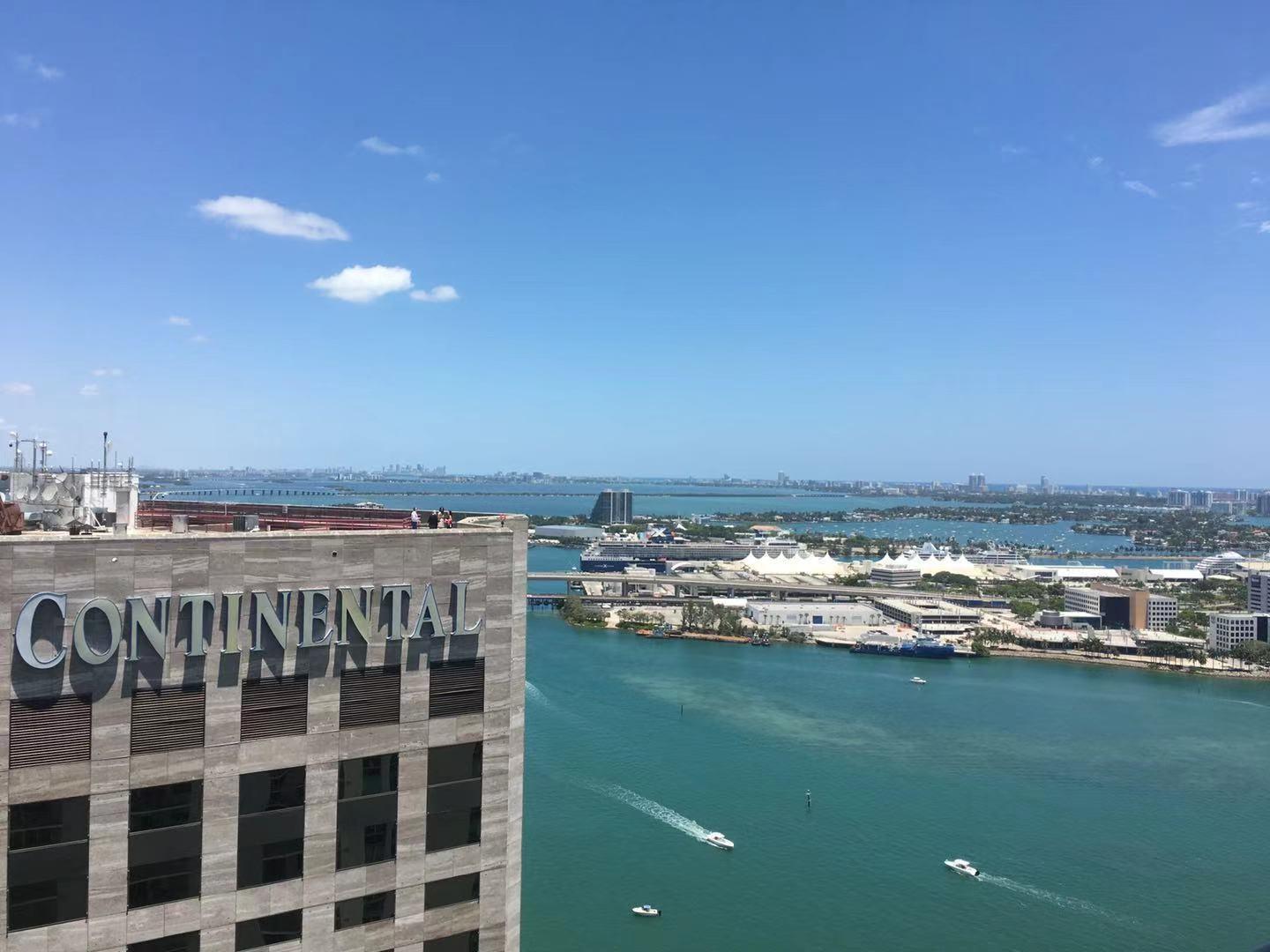 An elevated view of a building with Continental signage overlooking a bay with cruise ships — 335 S Biscayne Boulevard # 4004, Miami FL 33131, MIAMI, FL