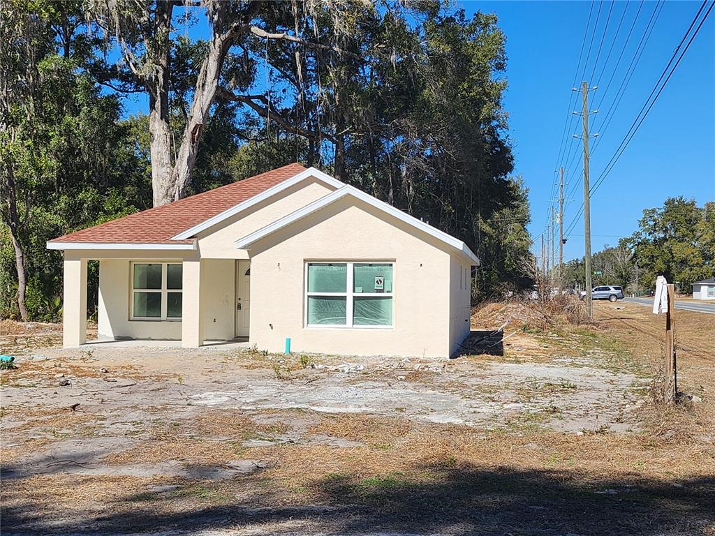A single-story house with a concrete driveway and a large tree in the yard — 3591 SE 139TH STREET, SUMMERFIELD, FL