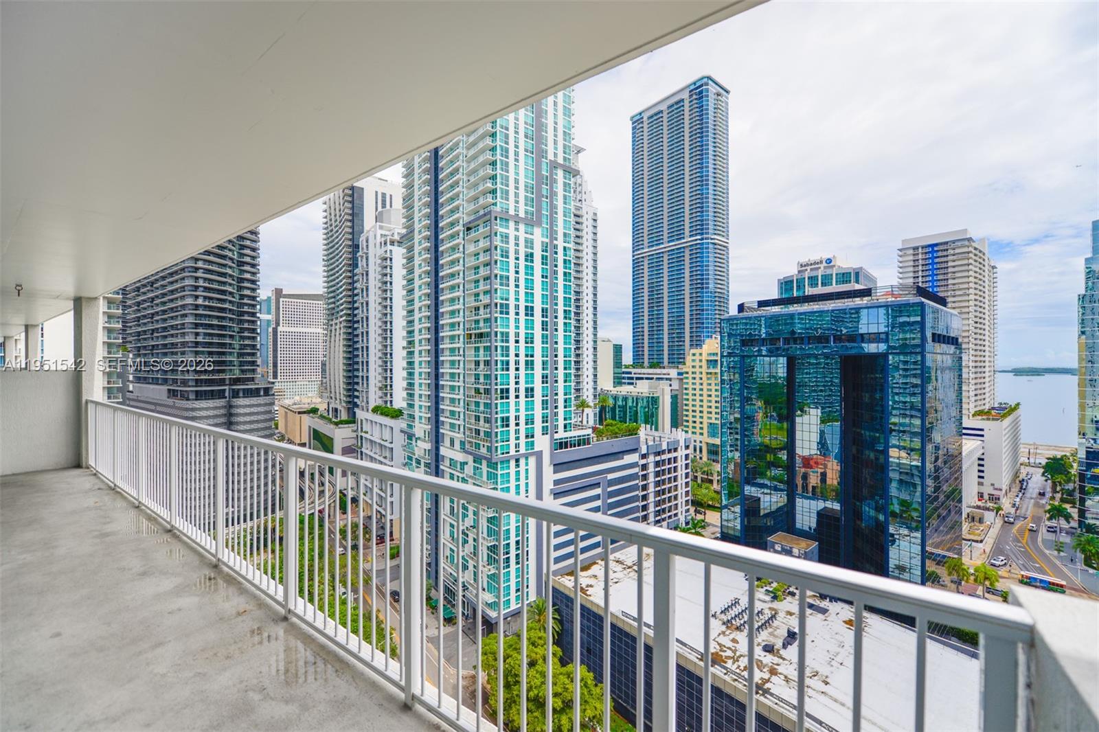 A balcony with a white railing overlooks a dense urban skyline with tall glass skyscrapers — 1250 S Miami Ave # 1906, Miami FL 33130, MIAMI, FL