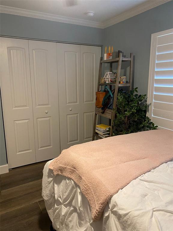 A bedroom features a white closet, a wooden ladder shelf, and a bed with bedding — 2735 SW 35TH PLACE UNIT 804, GAINESVILLE, FL