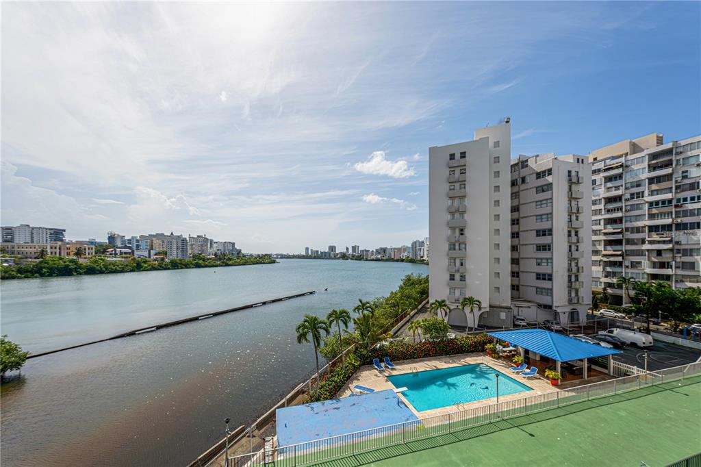An elevated view of a swimming pool, a river, and surrounding high-rise apartment buildings — 20 DELCASSE STREET UNIT 401, SAN JUAN, PR