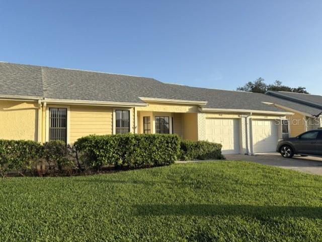A yellow single-story house with a gray shingled roof and an attached garage — 4809 WAKEFIELD COURT, NEW PORT RICHEY, FL