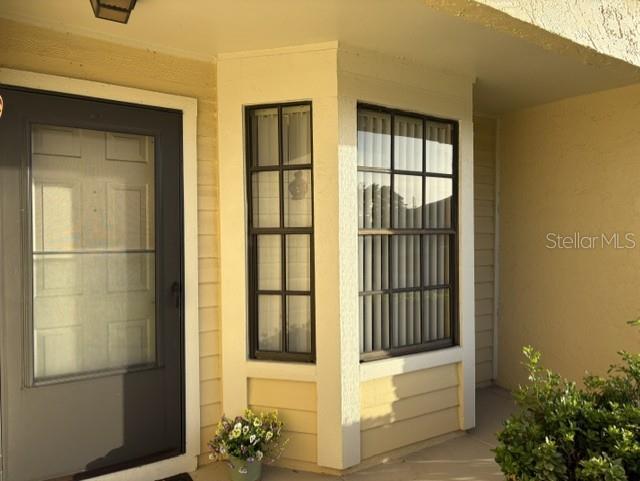 A front entrance with a dark door and a bay window on a yellow house — 4809 WAKEFIELD COURT, NEW PORT RICHEY, FL