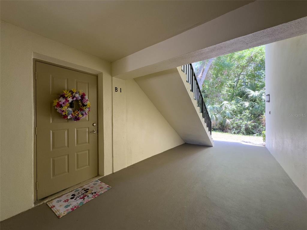 An exterior view of a building entrance with a door, a wreath, and stairs — 3188 LAKE PINE WAY S UNIT B1, TARPON SPRINGS, FL