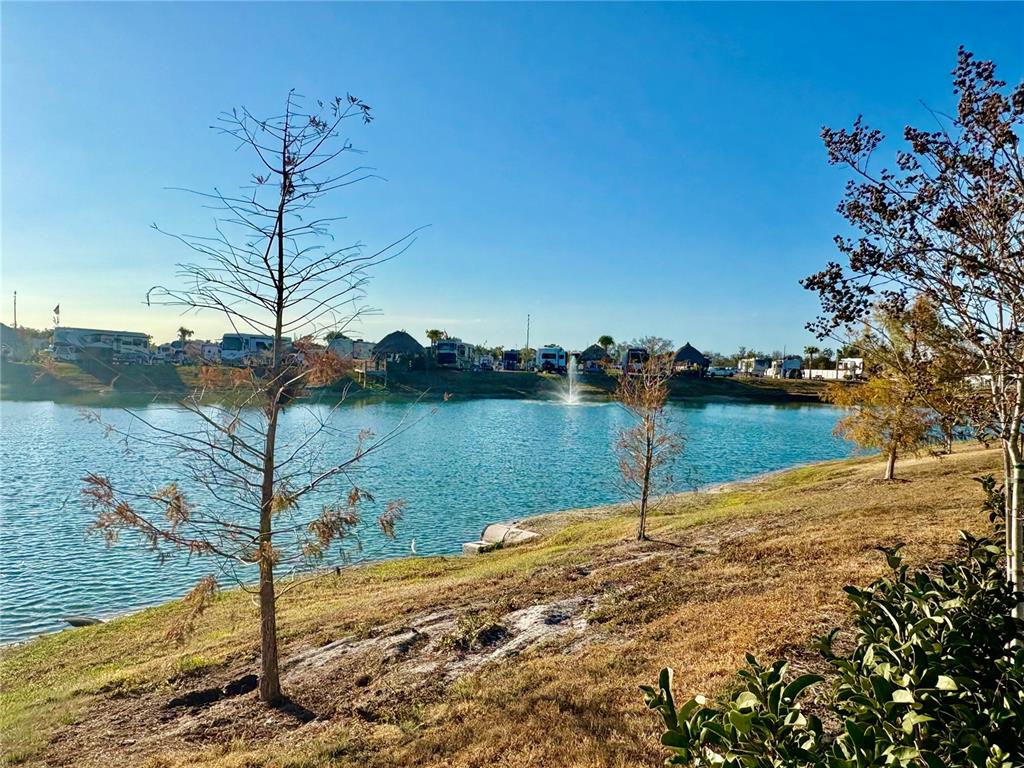 A pond with a fountain sits in front of an RV park under a clear sky — 259 HORIZON ROAD, PUNTA GORDA, FL